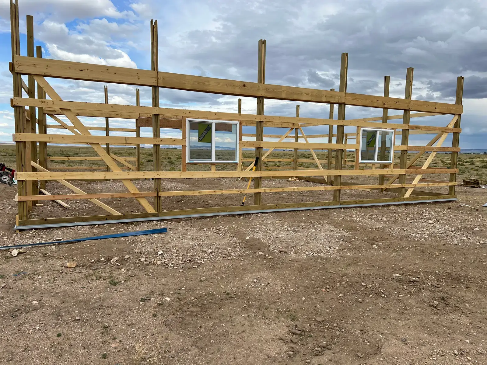 Timber posts and horizontal wall framing with two windows fitted in the open wall.